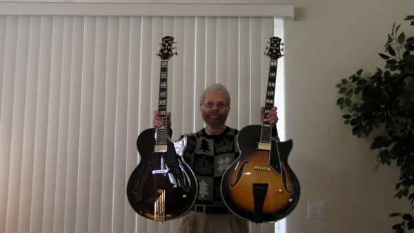 Donald Grass holding his two Conti archtop guitars